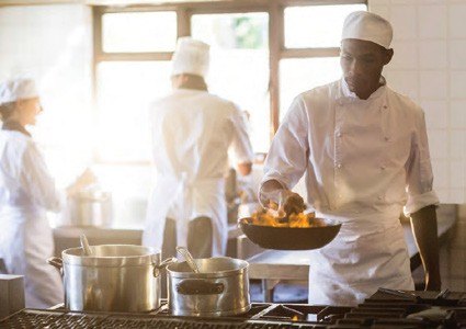 Chefs cooking in a camp kitchen