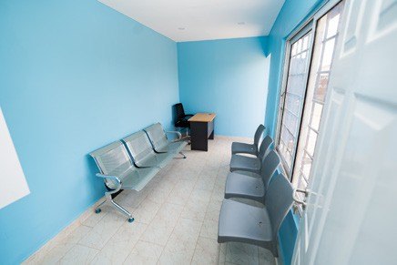 Clinic waiting room with blue walls and seating