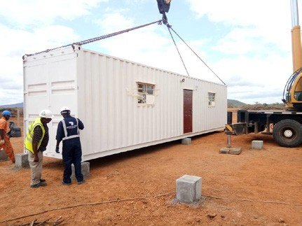 Crane lifting a container unit into position on site