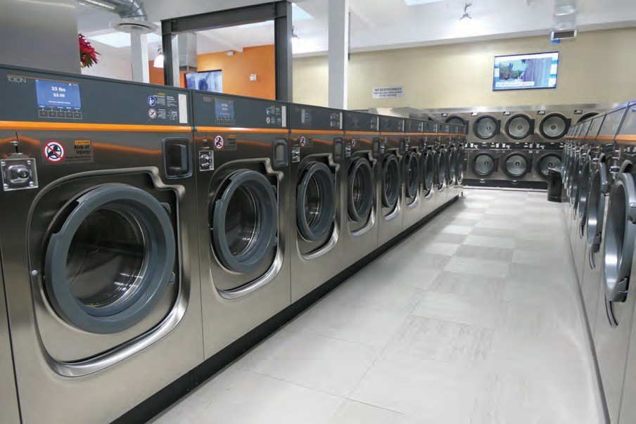 Camp laundry room with rows of commercial washing machines