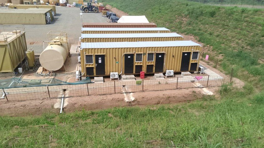 Rows of yellow container accommodation units at a pipeline camp